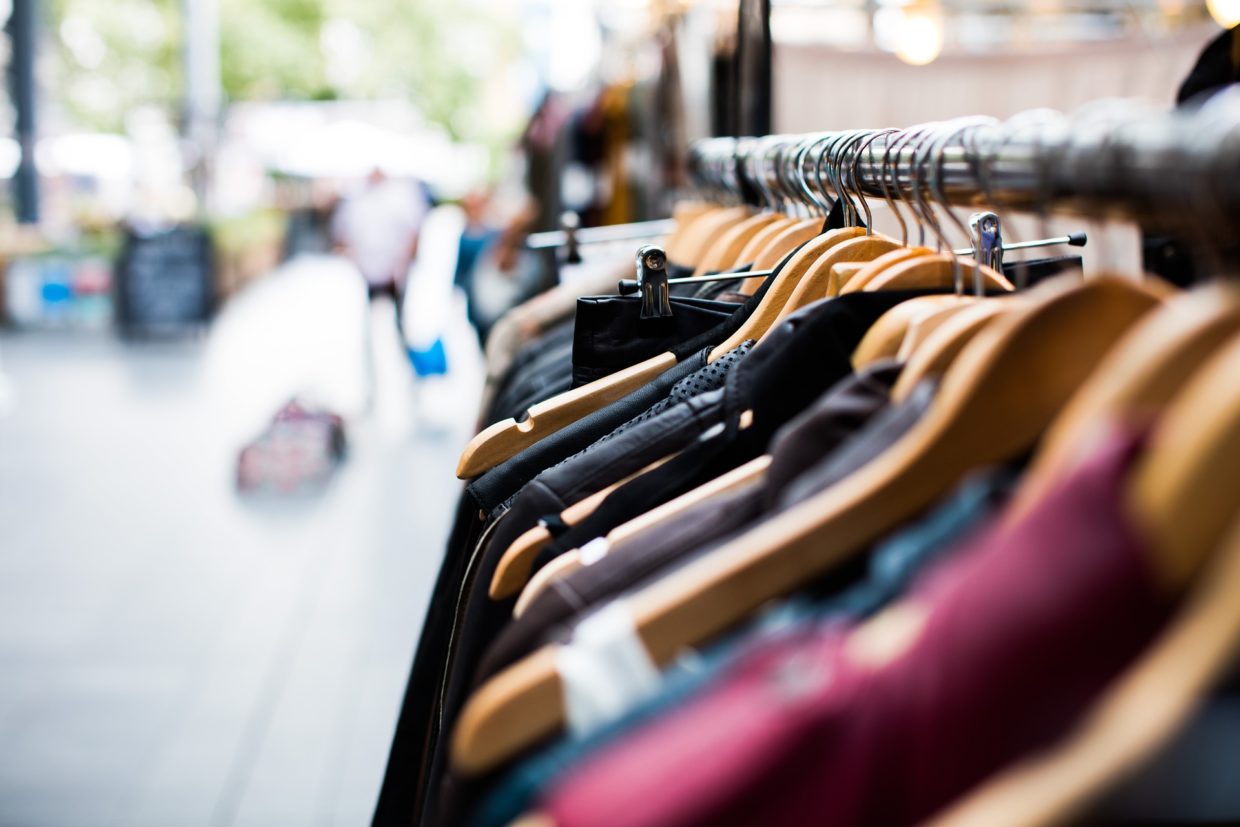 Row of a variety of clothes on a hanger outside.