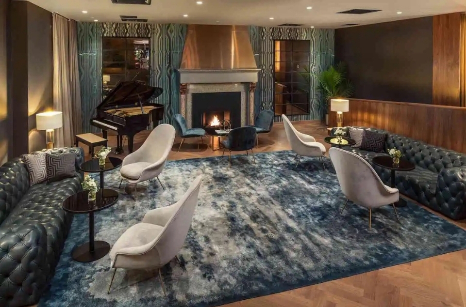 The MAD Piano Lounge with fireplace, piano, and lounge seating.